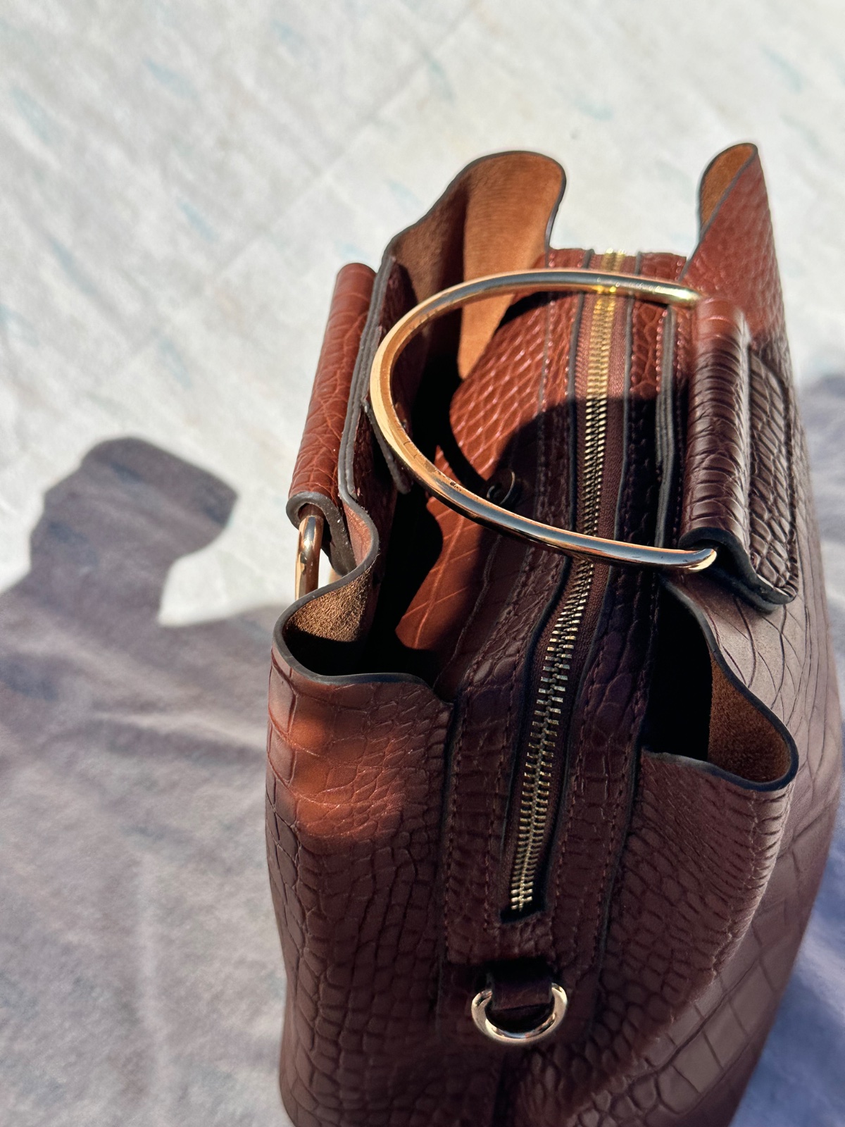 Le produit sélectionné est un sac à main pour femme en simili-cuir marron avec un effet croco.