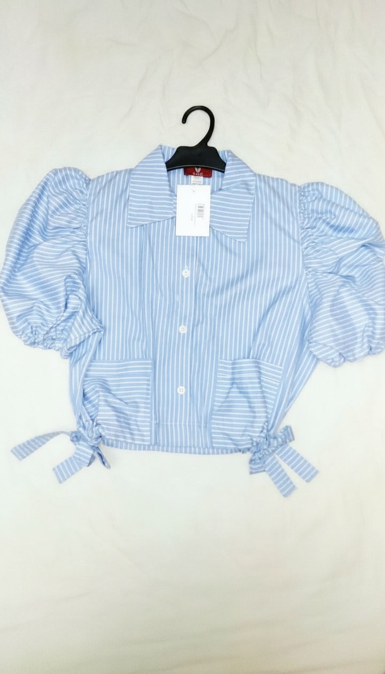 Chemise rayée bleu et blanc,taille S/M présente des manches bouffantes volumineuses et des liens à nouer à la taille.