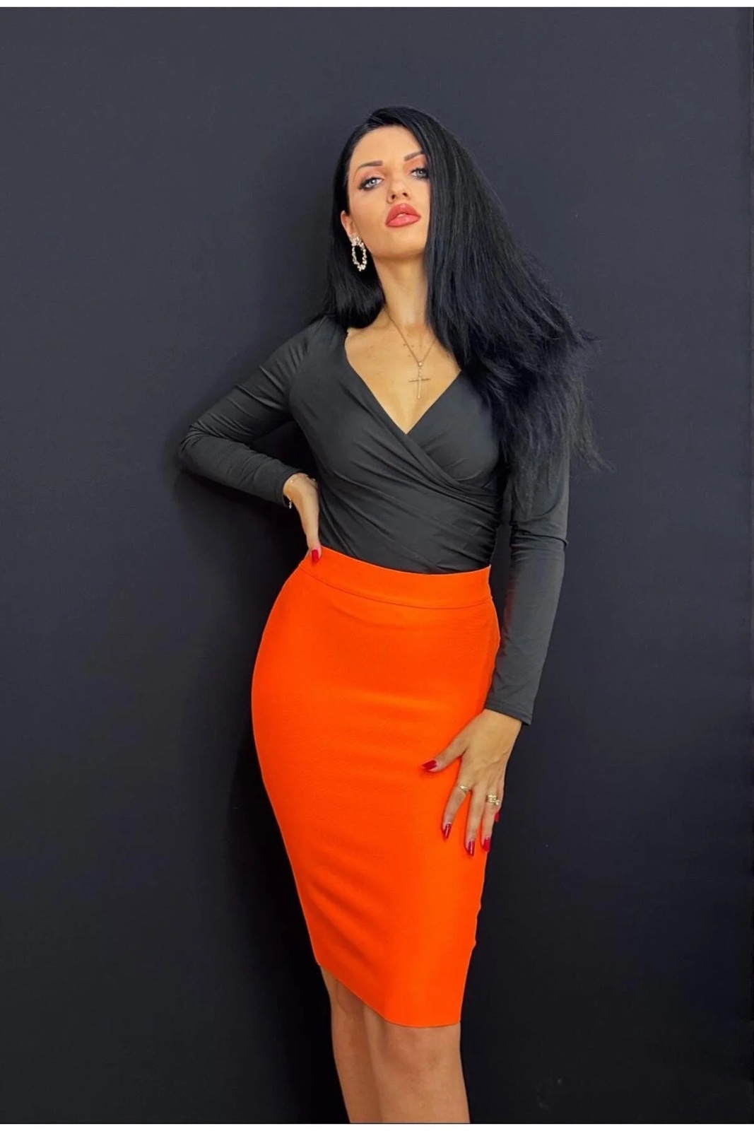 Jupe orange vif fluorescente, taille M  de la marque  , est confectionnée dans un tissu bandage ajusté qui épouse les formes.