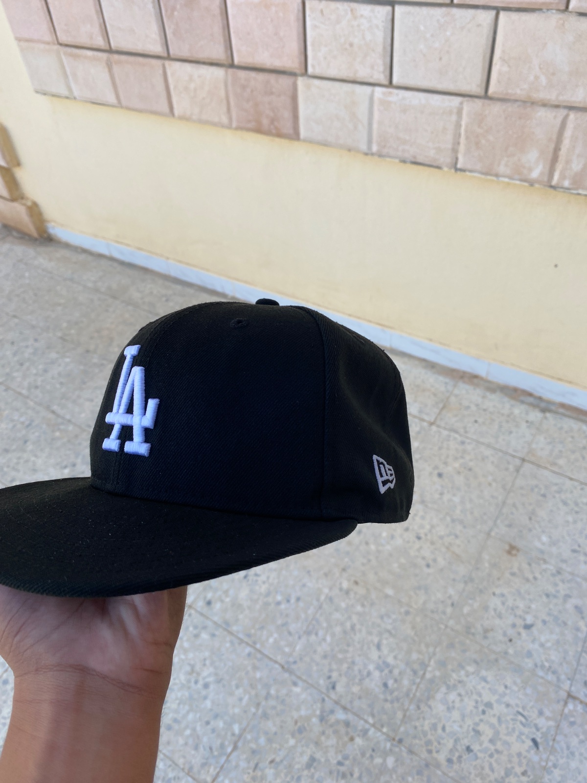لون الأبيض، مع شعار New Era على الجانب. ستايل ستريت وير عصري،