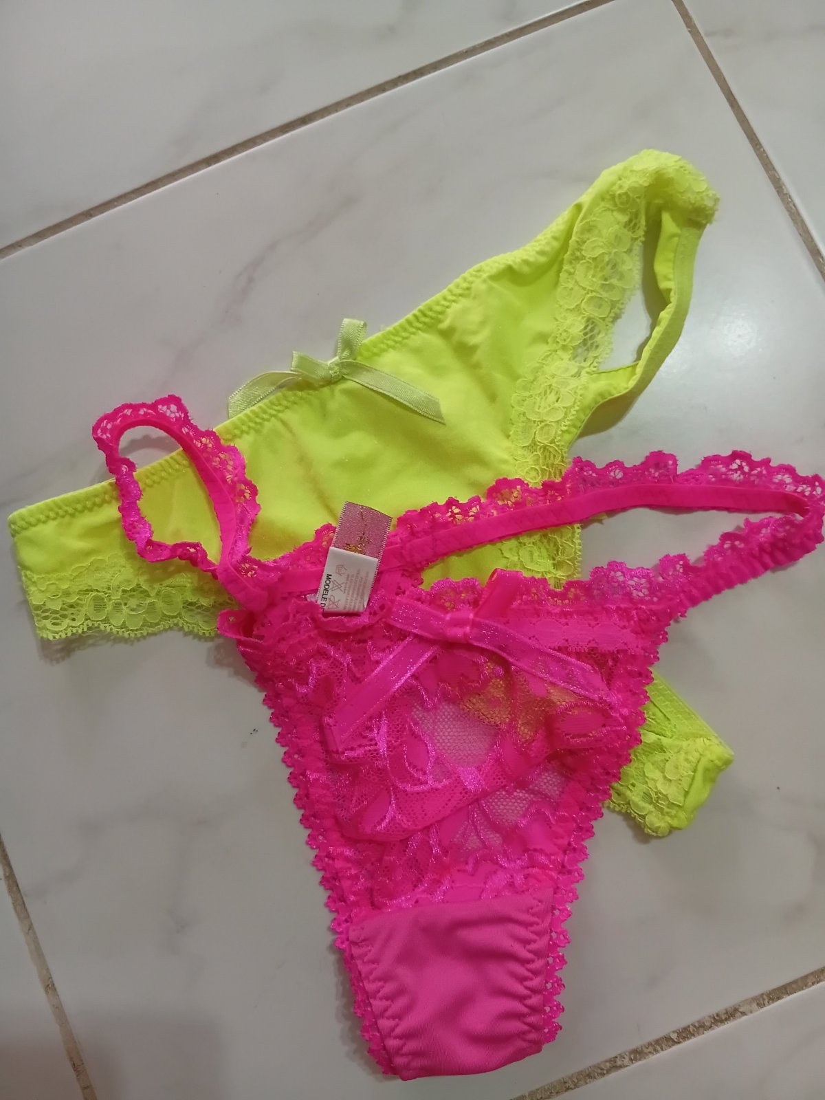 ✨️✨️string en satin et dentelle vert lime/jaune fluo de la marque française de lingerie Soleil Sucré. Il se caractérise par des bordures en dentelle délicate, un petit nœud décoratif sur le devant ainsi qu'une étiquette rose distinctive de la marque