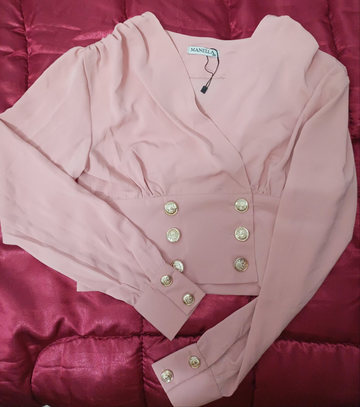 Une chemise croisée rose poudré Manella avec des boutons dorés.