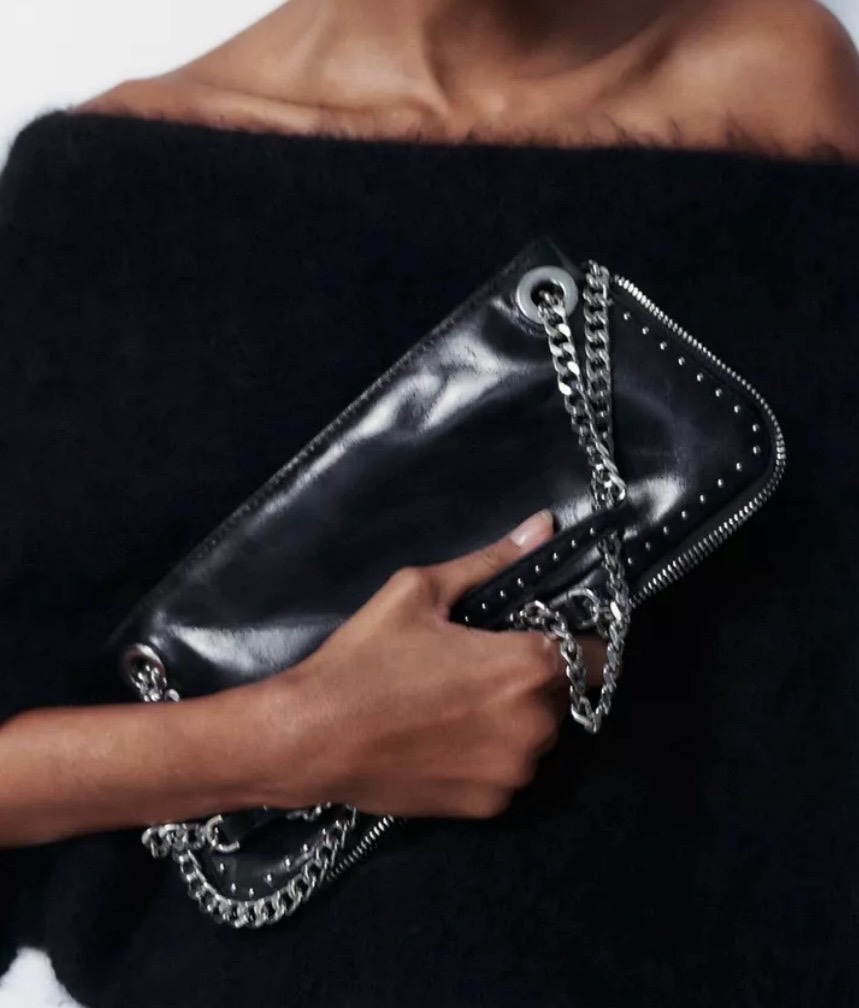 Sac à bandoulière noir de chez Zara présente des détails cloutés ainsi qu'une sangle en chaîne argentée