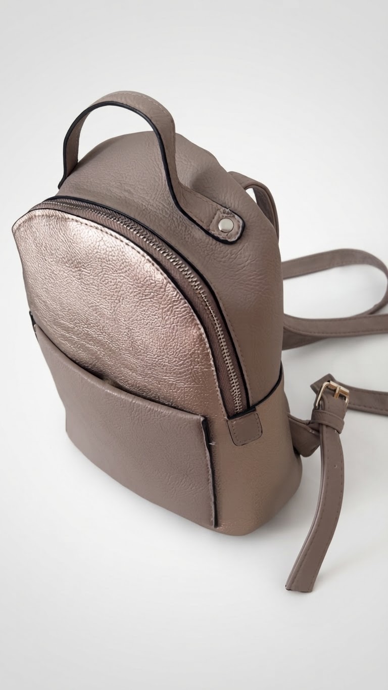 Sac à dos en cuir présente une couleur taupe/gris clair avec une poche avant arrondie en finition métallisée or rose