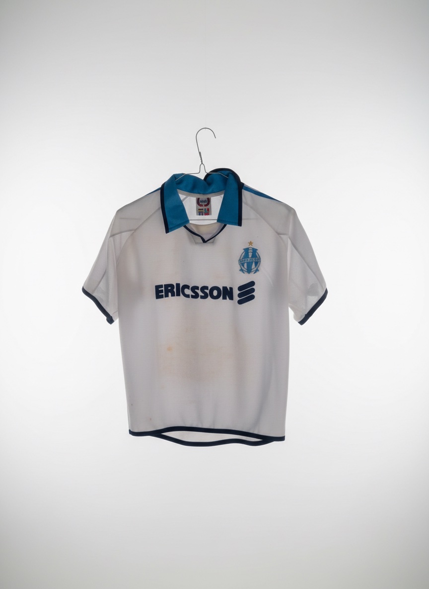 Ce maillot semble être un maillot de Olympique de Marseille avec le sponsor Ericsson, datant probablement de la période 1998-1999 ou 1999-2000.