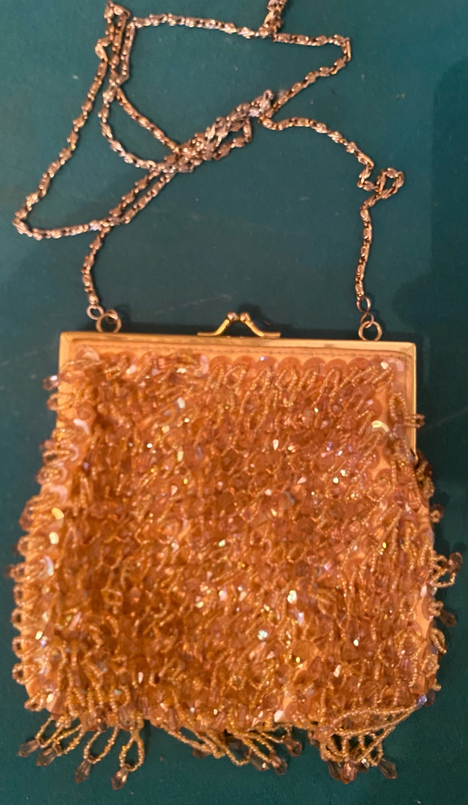 Cette élégante pochette de soirée est ornée de perles dorées et d'une chaîne
