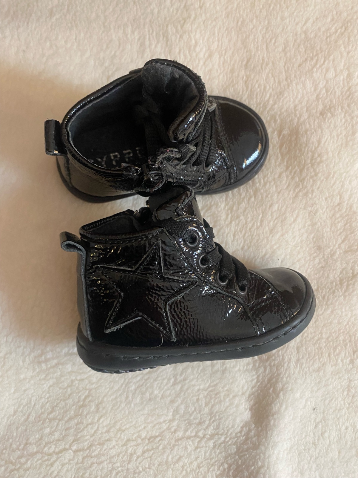 Bottines pour bébé ou enfant, caractéristiques d'un style verni noir avec un motif d'étoile sur le côté