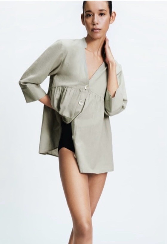 Une blouse boutonnée de couleur vert sauge de la marque Zara.