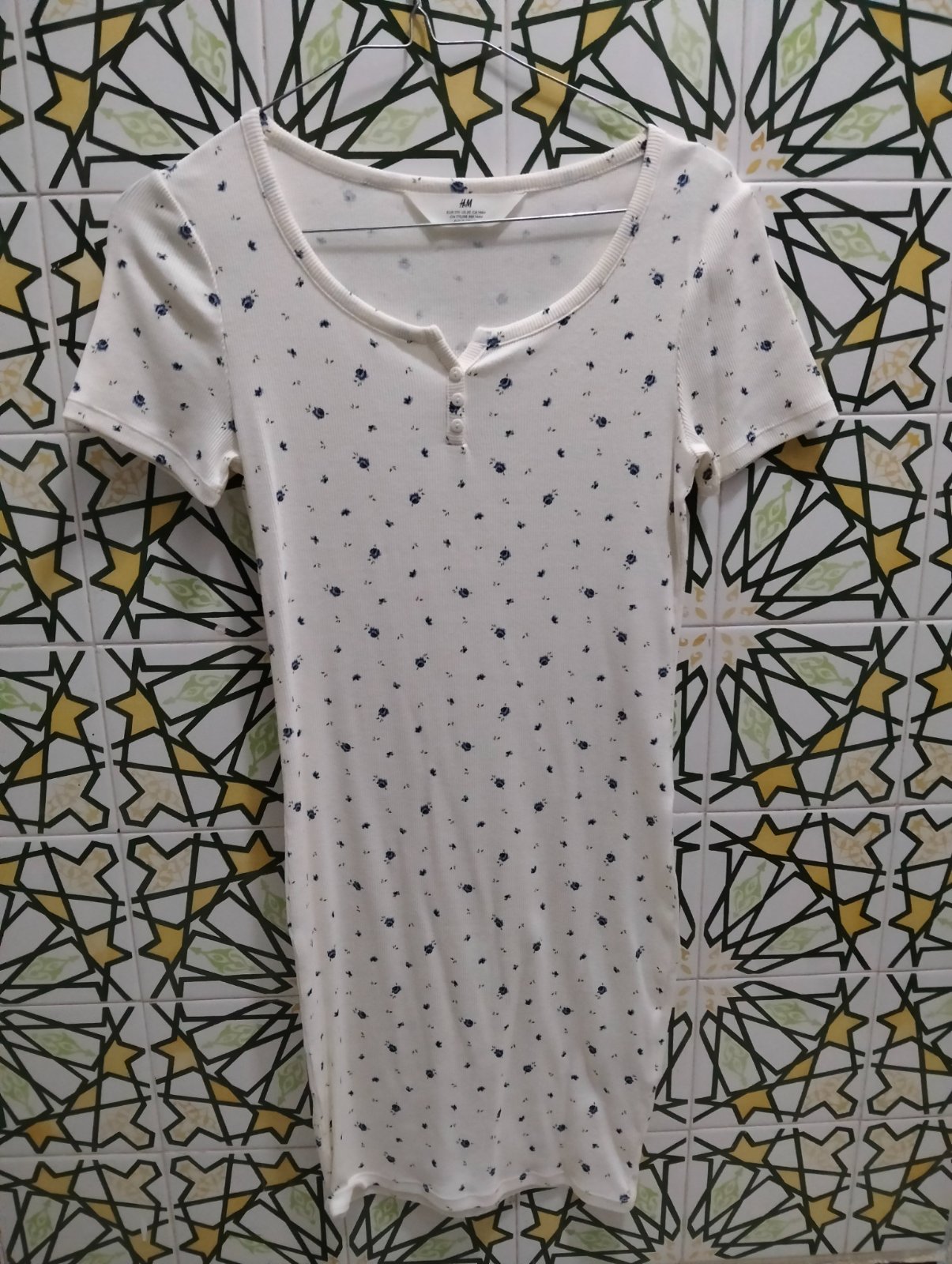 Une robe blanche avec des petites fleurs en bleu