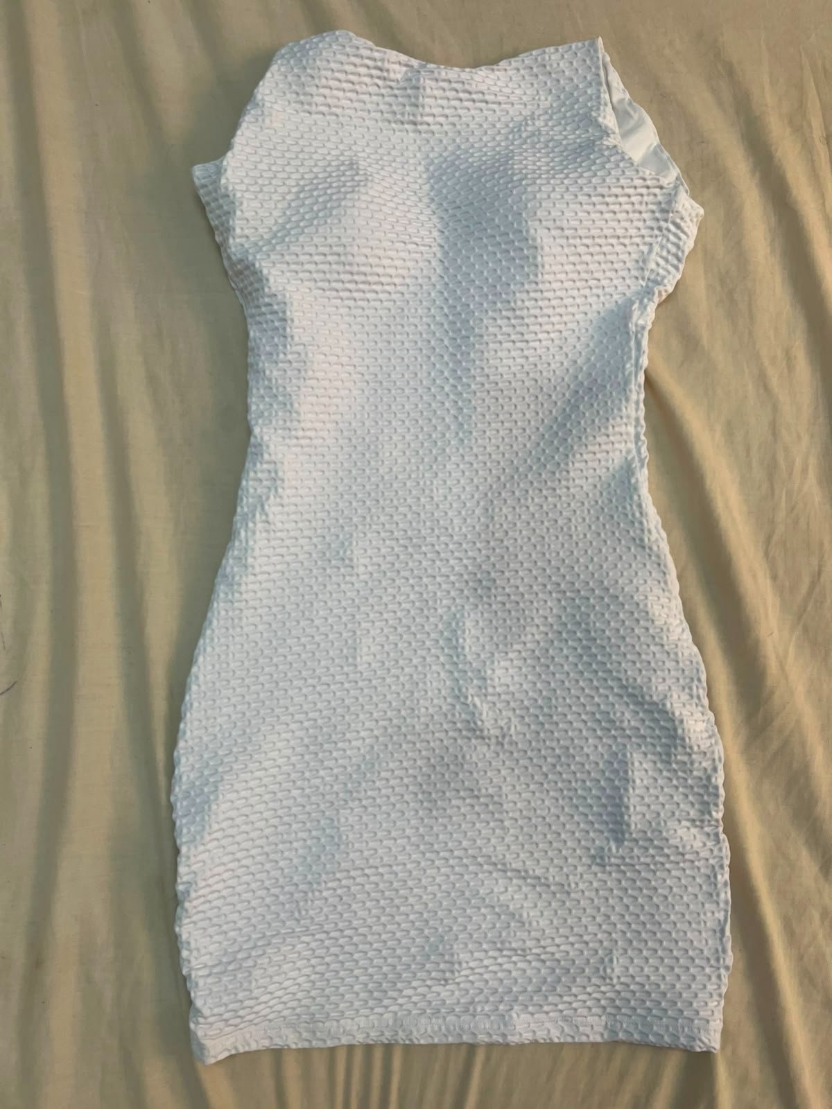 Robe présente une coupe courte et ajustée avec un motif texturé en relief, idéal pour un look d'été ou de soirée