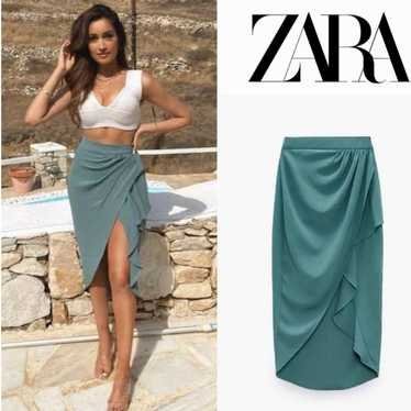Jupe midi de marque Zara est caractérisée par son drapé frontal et une fente asymétrique