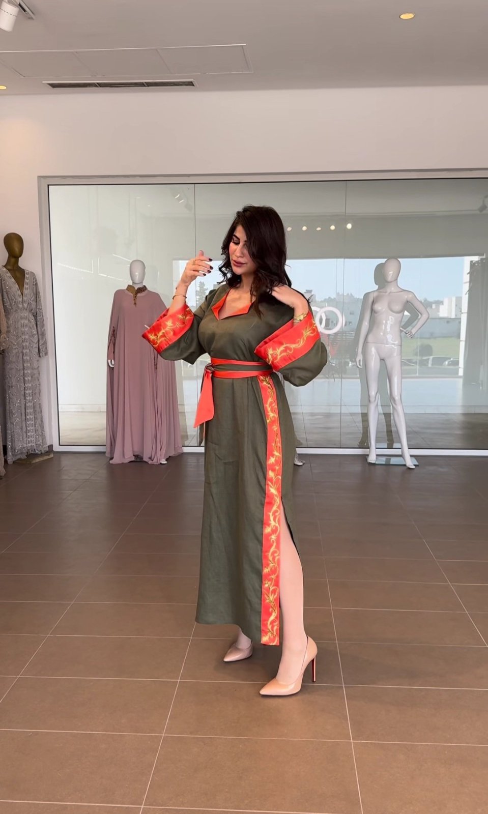 Longue robe en lin de couleur olive, agrémentée de détails rouge vif et d'une ceinture assortie, provenant de la collection "Ghada"