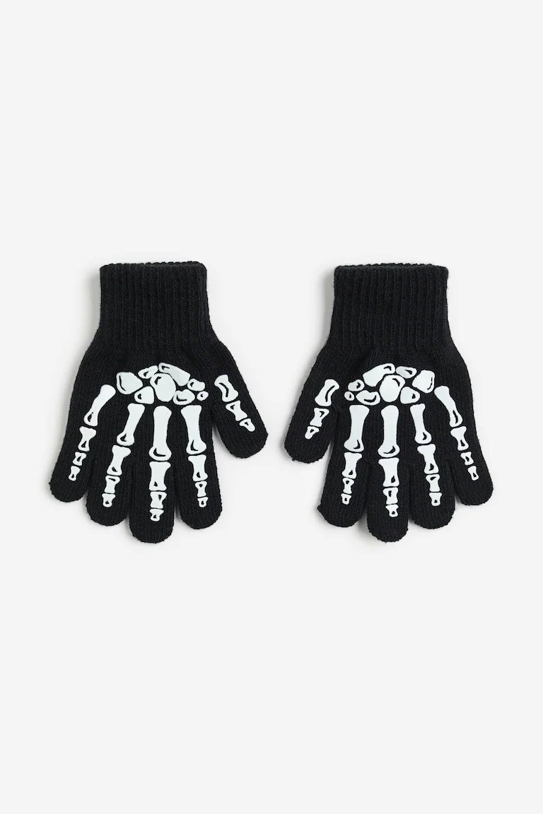 Gants noirs pour enfant arborent un motif de squelette blanc phosphorescent sur le dessus de la main