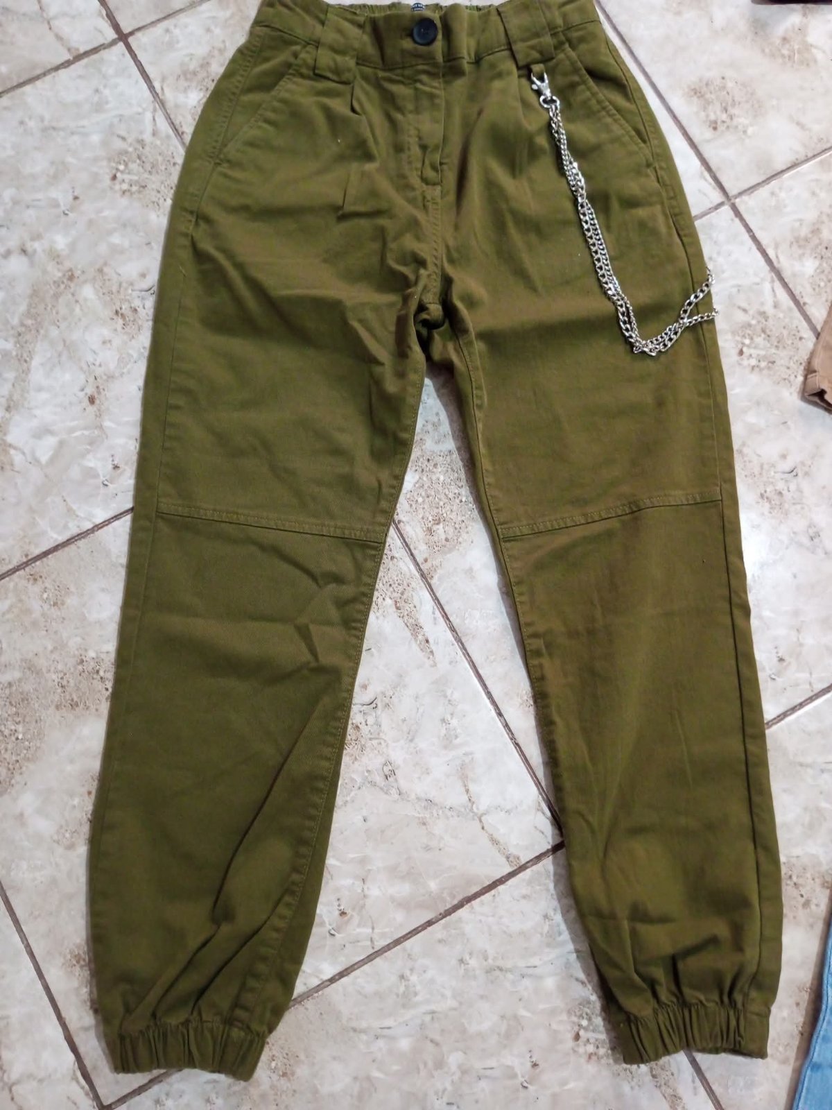 Pantalon cargo vert militaire de la marque Bershka se distingue par sa chaîne décorative amovible