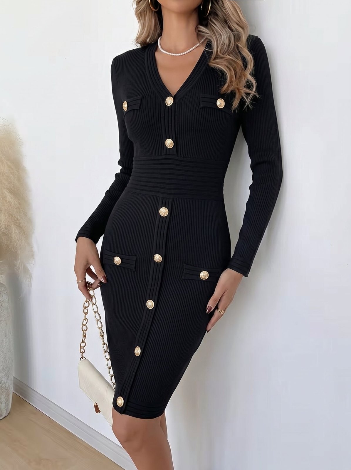 Une élégante robe longue noire en maille côtelée à col V, ornée de boutons dorés distinctifs sur le devant