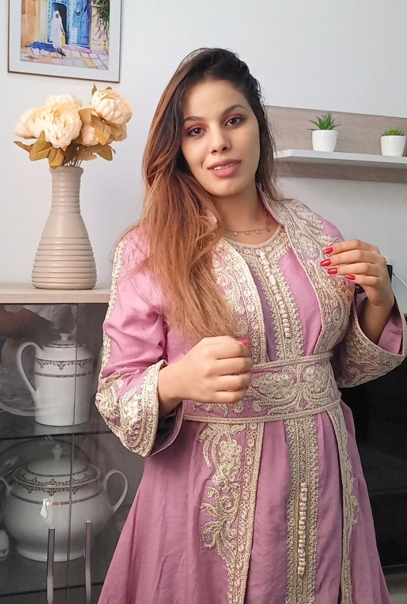 Caftan rose poudré présente une broderie dorée complexe sur le devant et la ceinture
