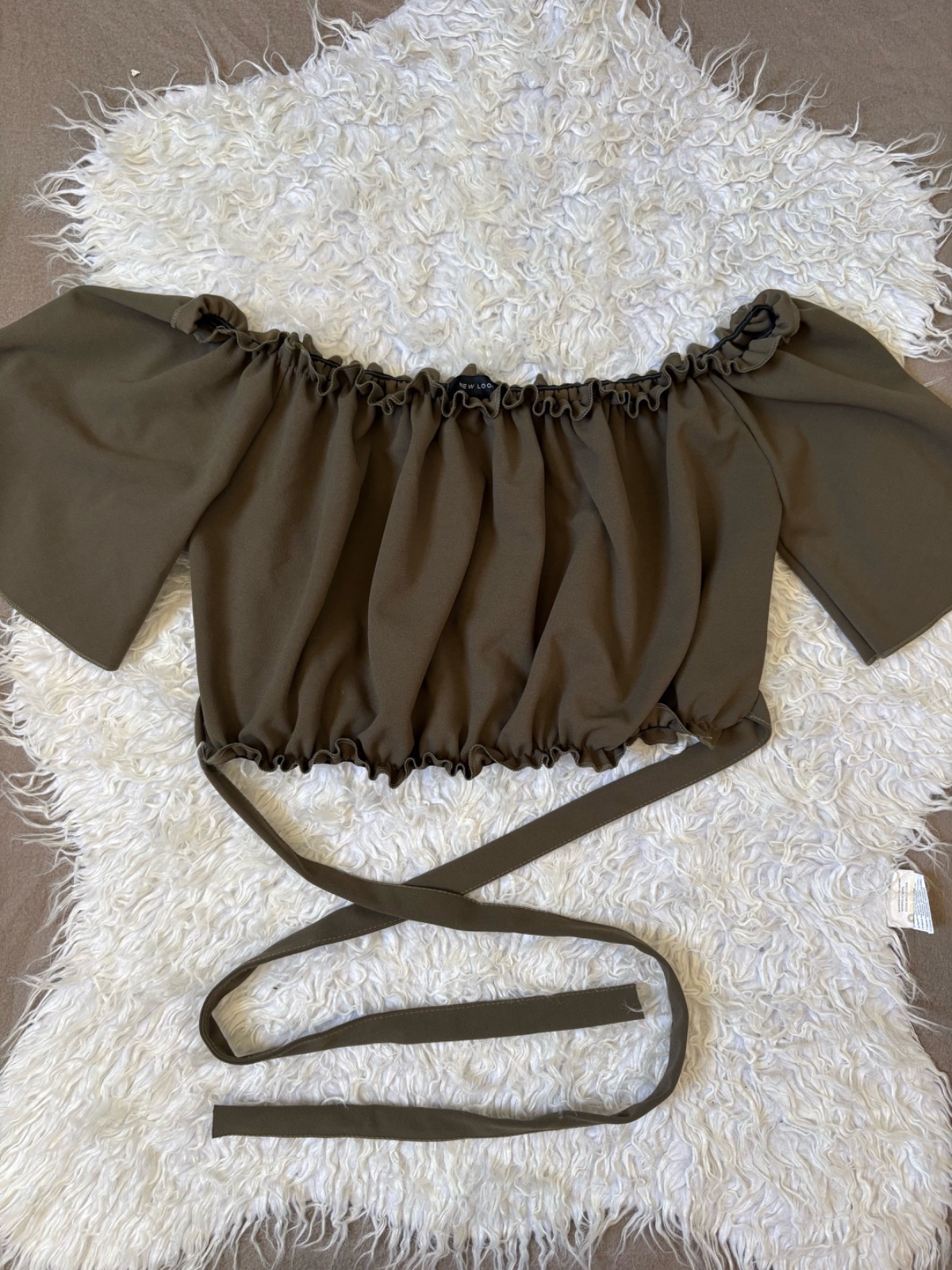 Sublime top chic vert kaki, coupe élégante off shoulder qui met délicatement les épaules en valeur. Une pièce féminine et raffinée avec une touche tendance, comme neuf, parfaite pour un look chic et sophistiqué.