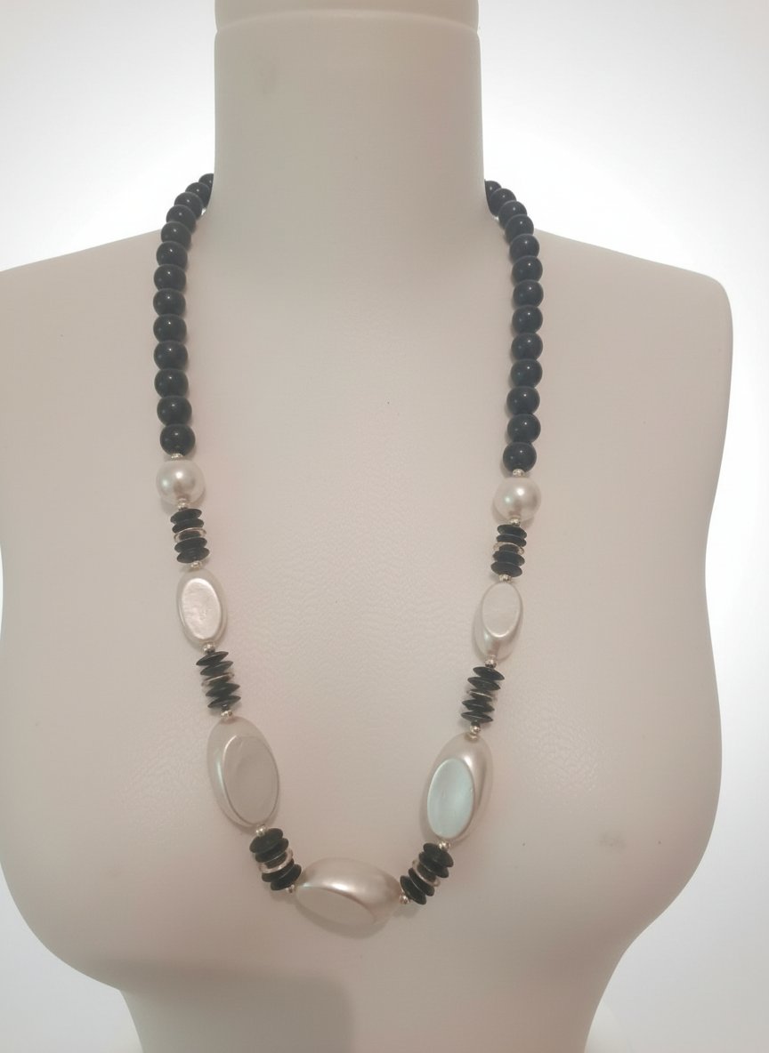 Un long collier en perles noires et blanches nacrées. 