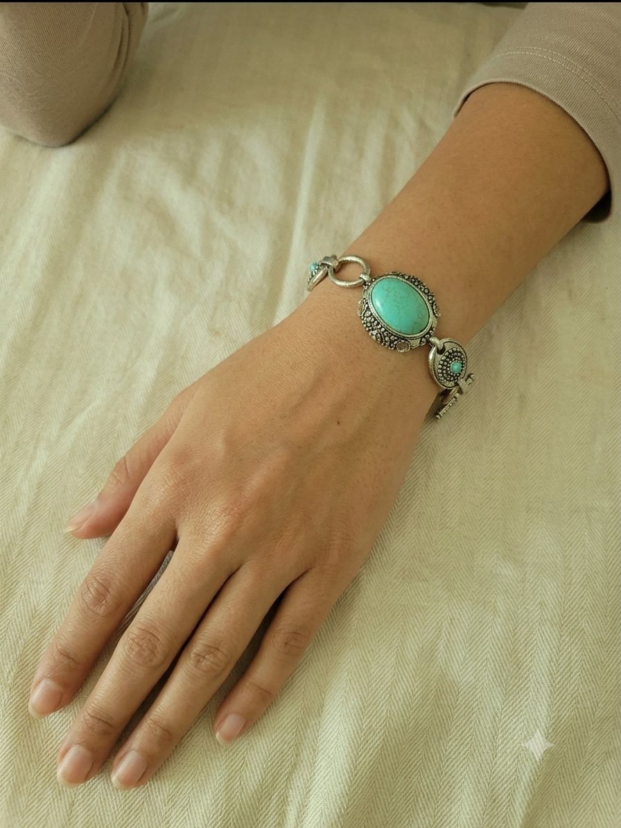 Bracelet en métal argenté et ses pierres turquoise.