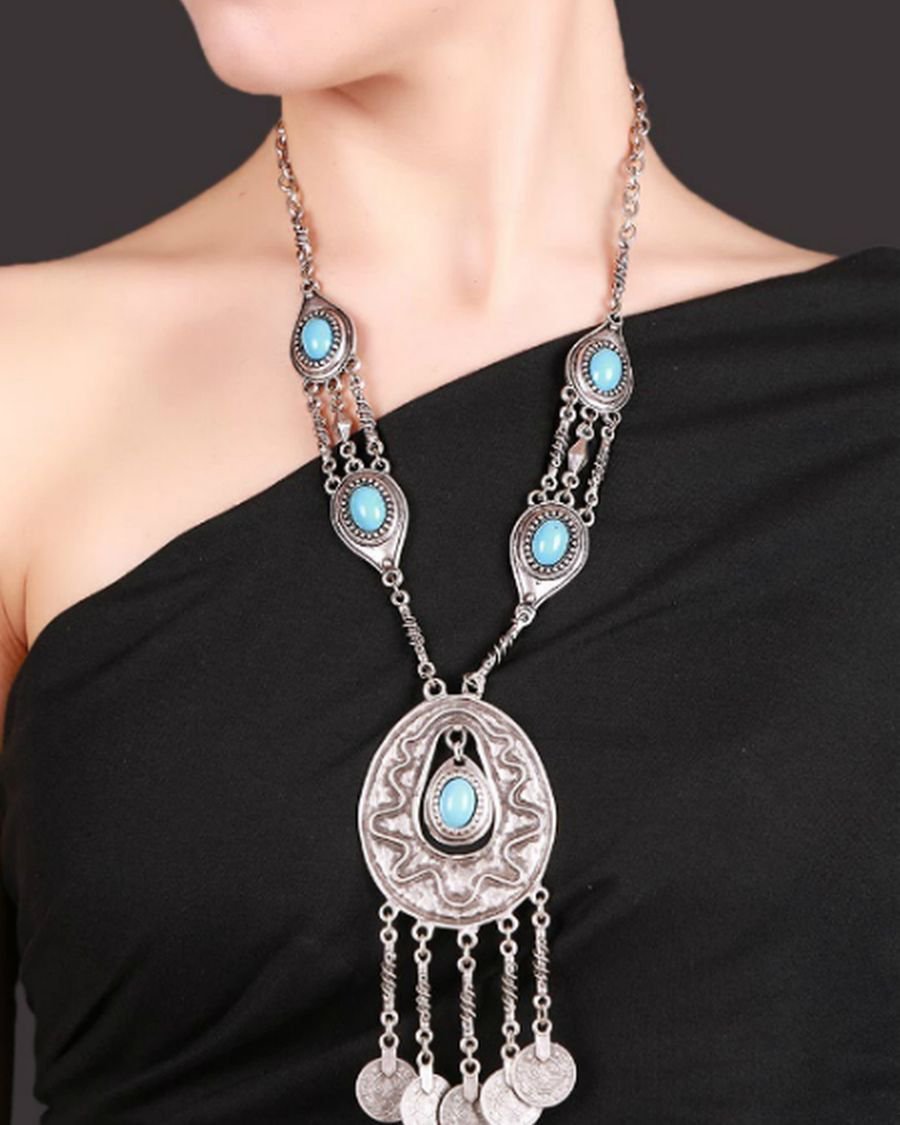 Colier argenté oxydé et des pierres turquoise.