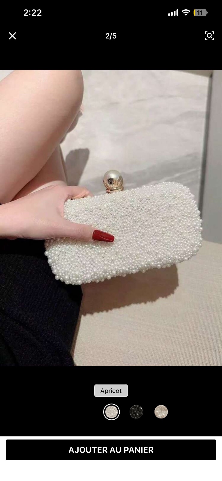 Pouchette soirée entièrement ornée de perles blanches et dispose d'un fermoir élégant avec une grosse perle
