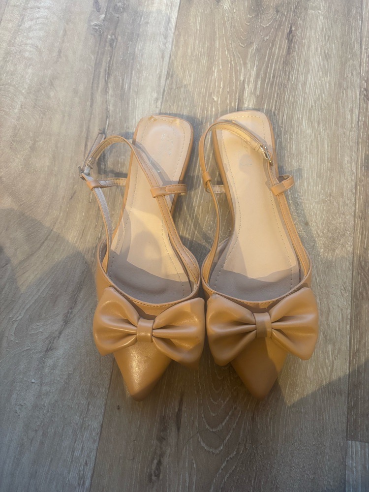  chaussures plates de couleur nude avec des nœuds décoratifs à l'avant