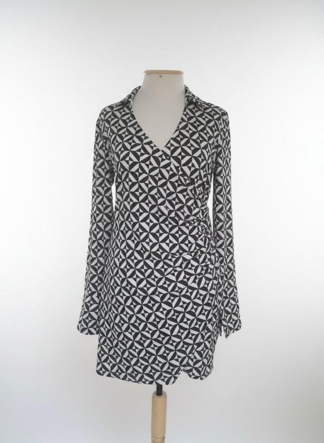 Robe H&M avec des formes géométriques en noir et vert très foncé drapé sur le côté en excellent état 
