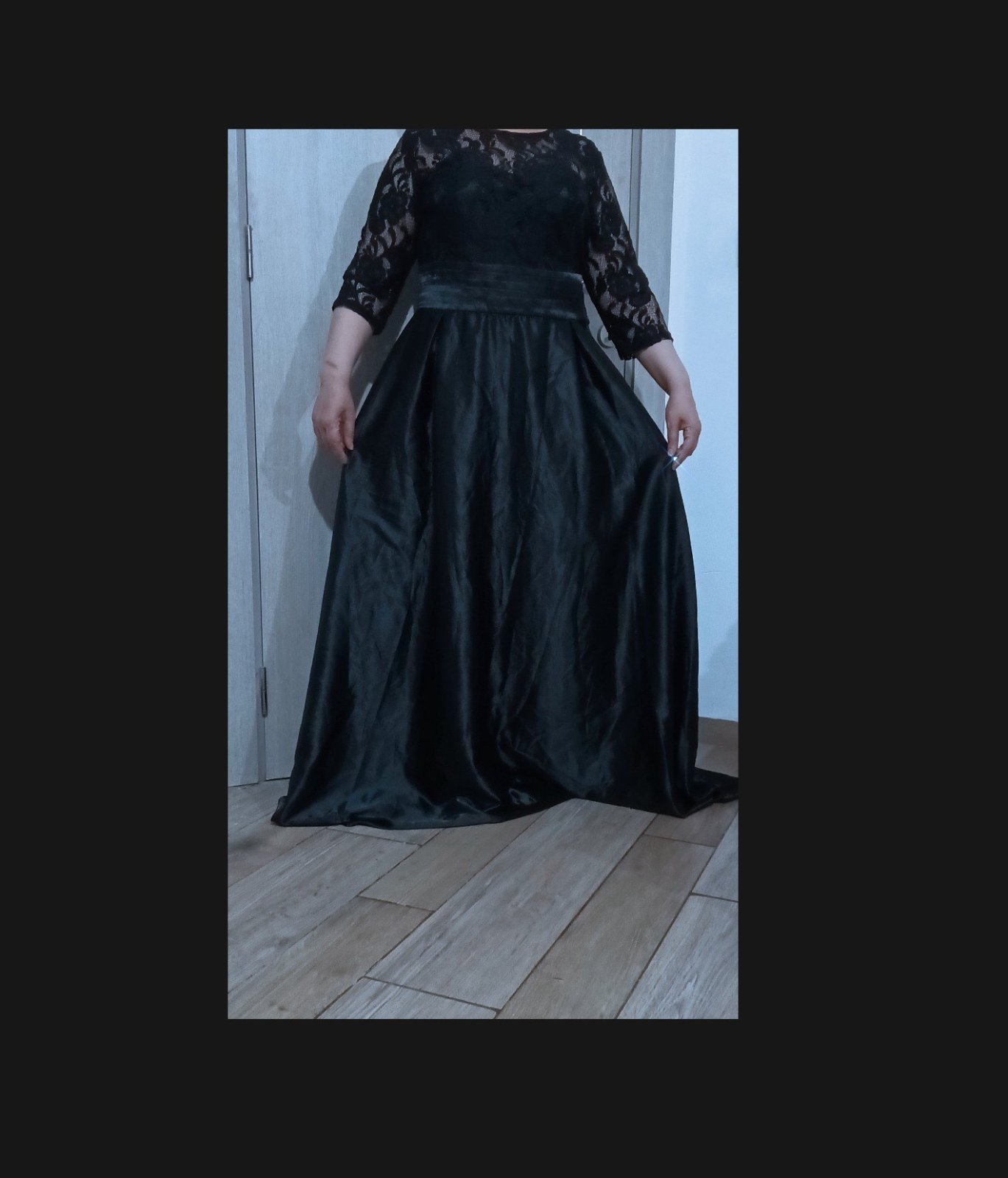 Une robe de soirée très chic en noir, alliant dentelle et satin,.