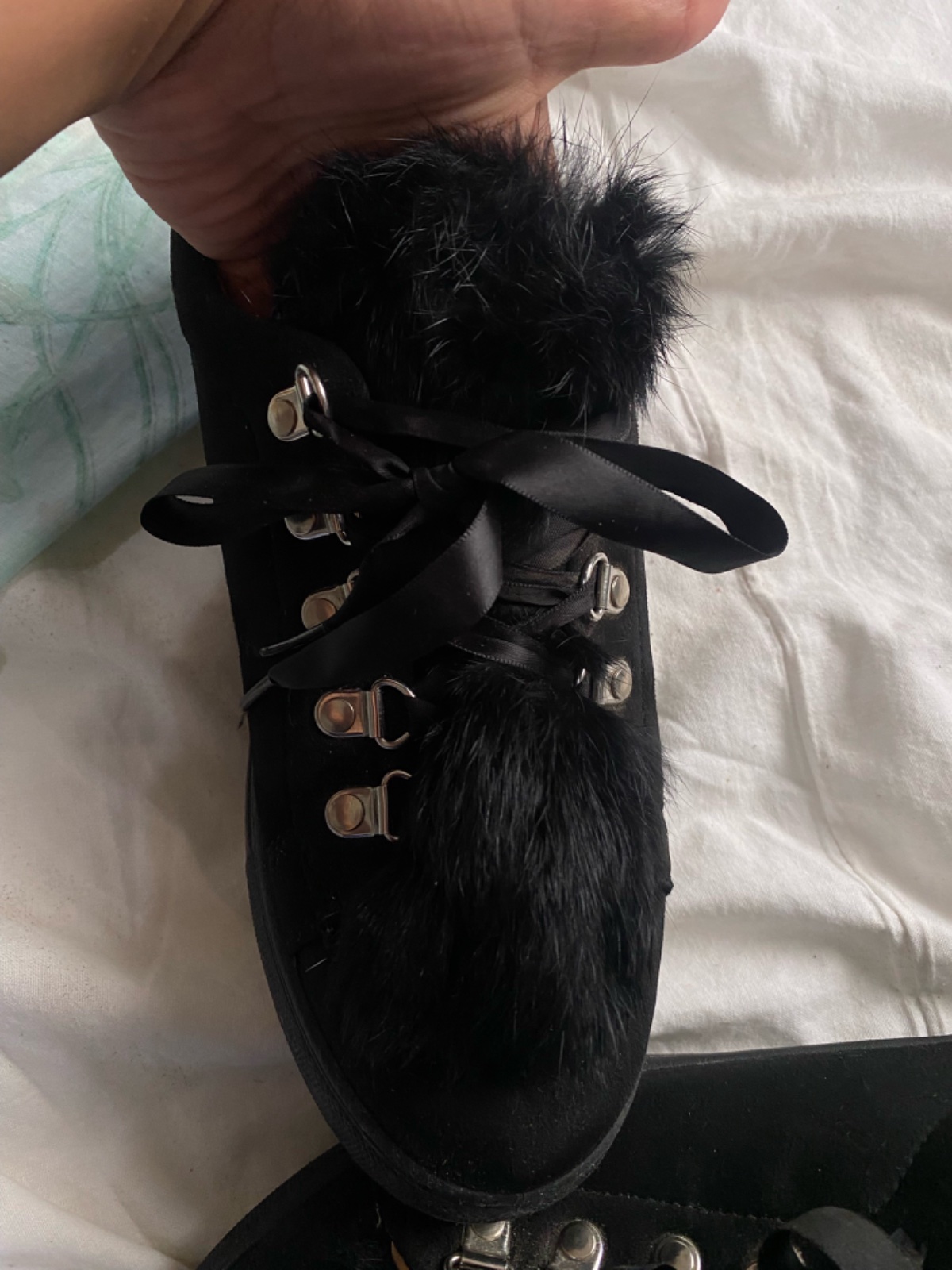 Ce sont des baskets 🇫🇷noires élégantes avec des lacets en ruban et des détails en fausse fourrure.