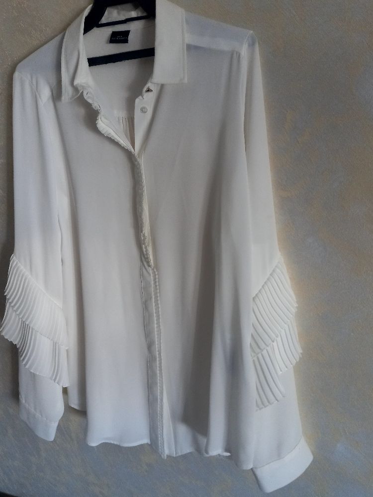 jolie chemise blanche à volants sur les manches très classe tt neuf jamais porté 