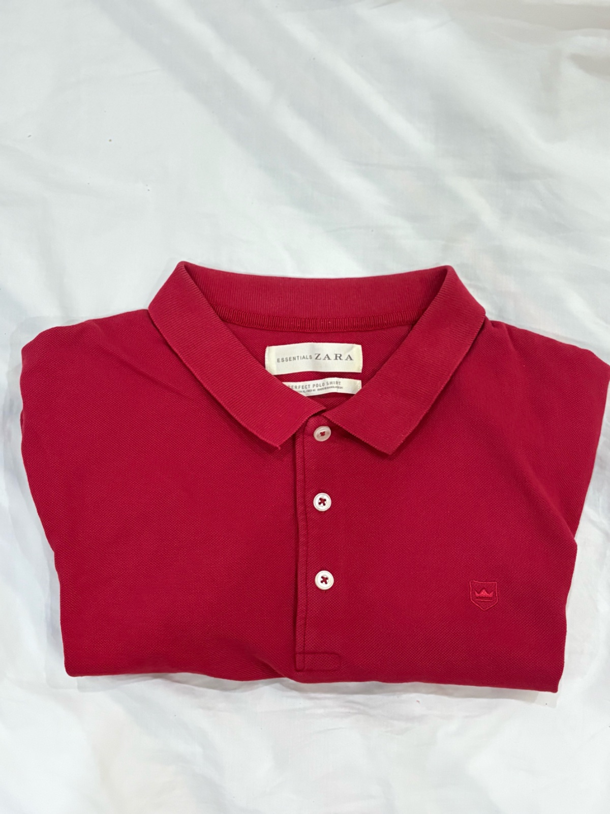 Polo rouge  Zara avec un petit logo brodé en forme de couronne