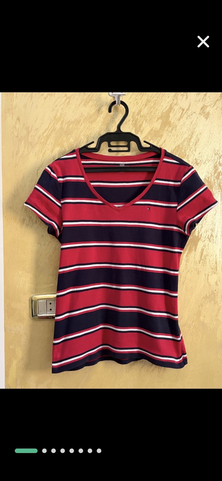 T-shirt Tommy Hilfiger arbore un motif rayé classique en rouge, bleu marine et blanc avec un col en V distinctif