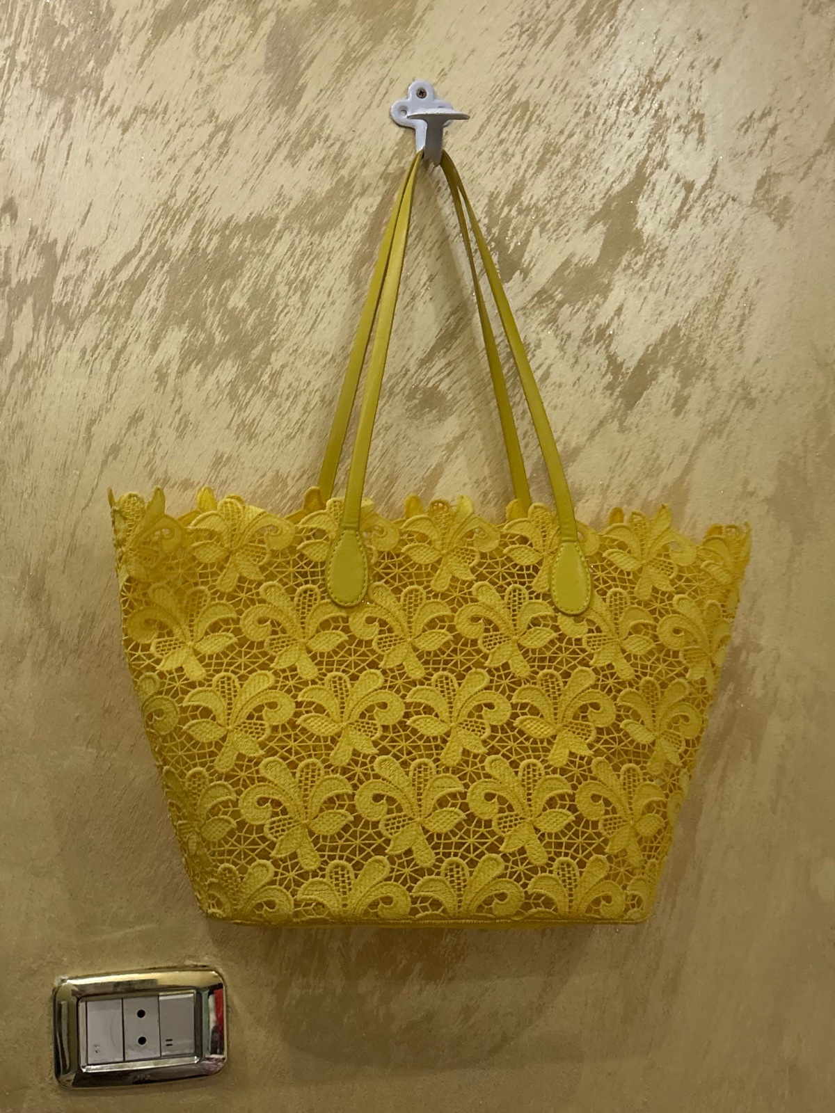 Sac cabas jaune vif fabriqué en dentelle  ajourée avec un motif floral complexe et des poignées assorties