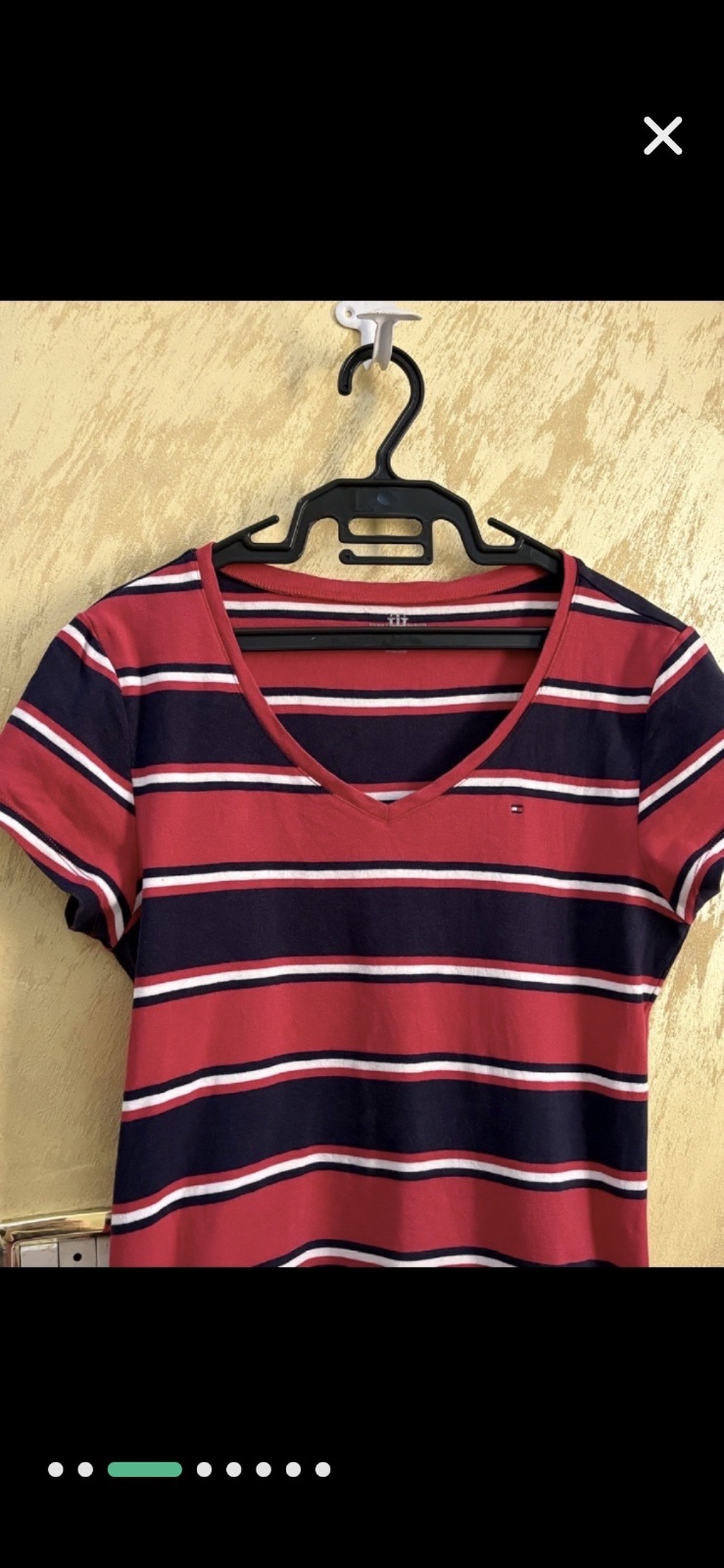 T-shirt Tommy Hilfiger arbore un motif rayé classique en rouge, bleu marine et blanc avec un col en V distinctif