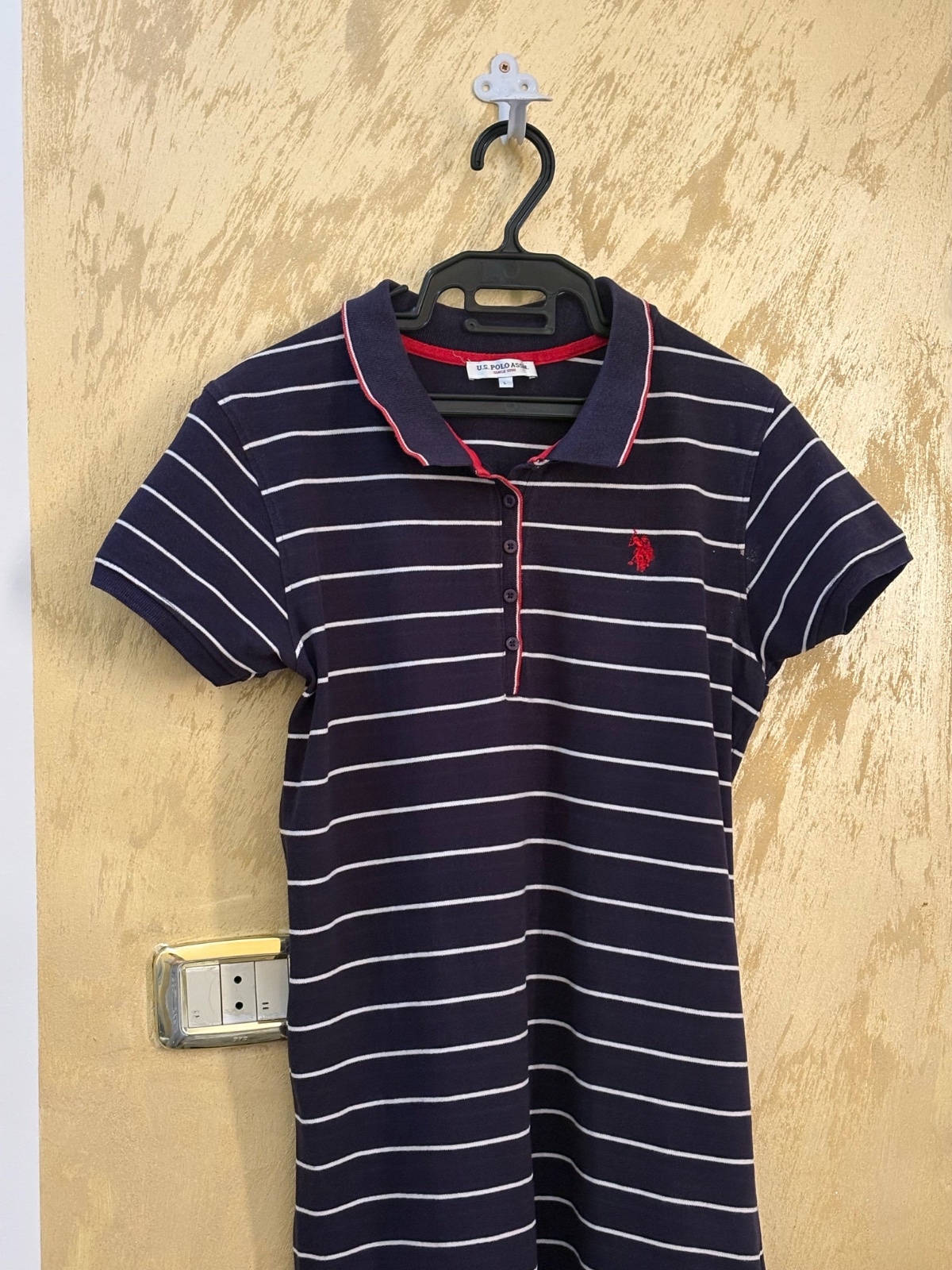 Robe polo U.S. Polo Assn. bleu marine à rayures blanches se distingue par son logo rouge brodé sur la poitrine et son col contrastant