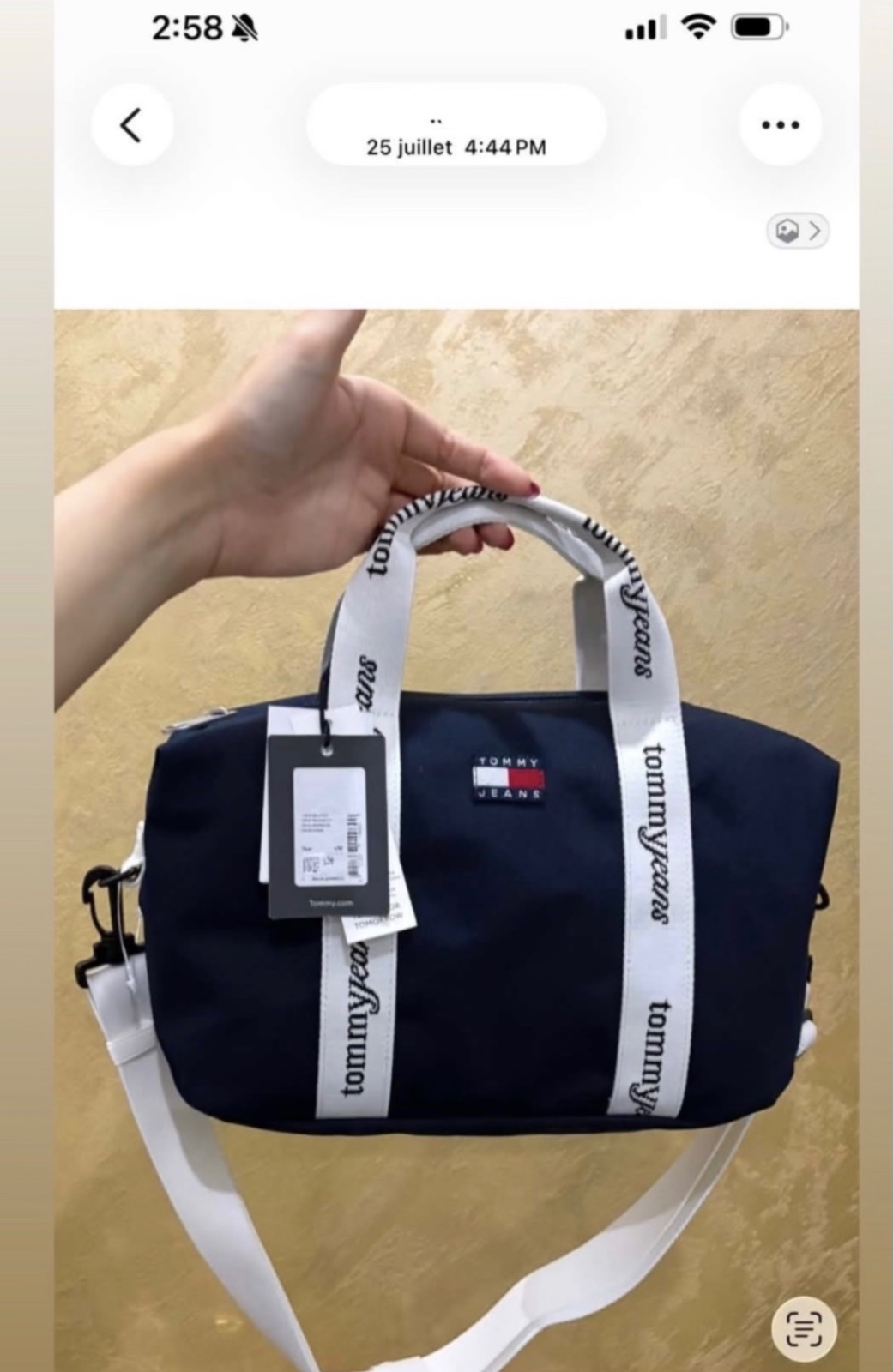 Sac fourre-tout Tommy Jeans en tissu bleu marine, caractérisé par ses poignées blanches ornées du logo répété de la marque acheté le 25 juillet 2026