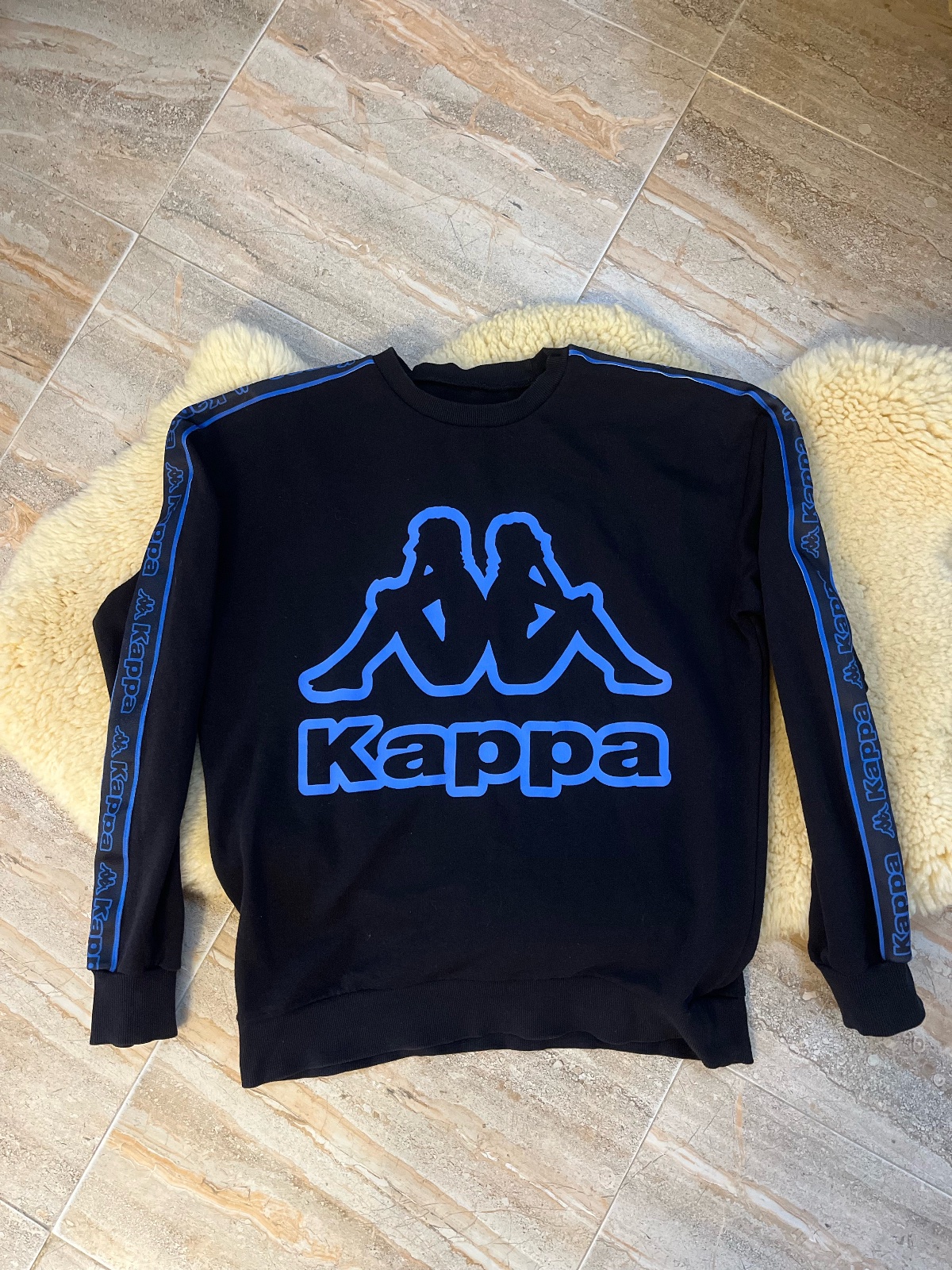 Sweatshirt Kappa noir avec le logo Omini bleu et des bandes latérales bleues sur les manches