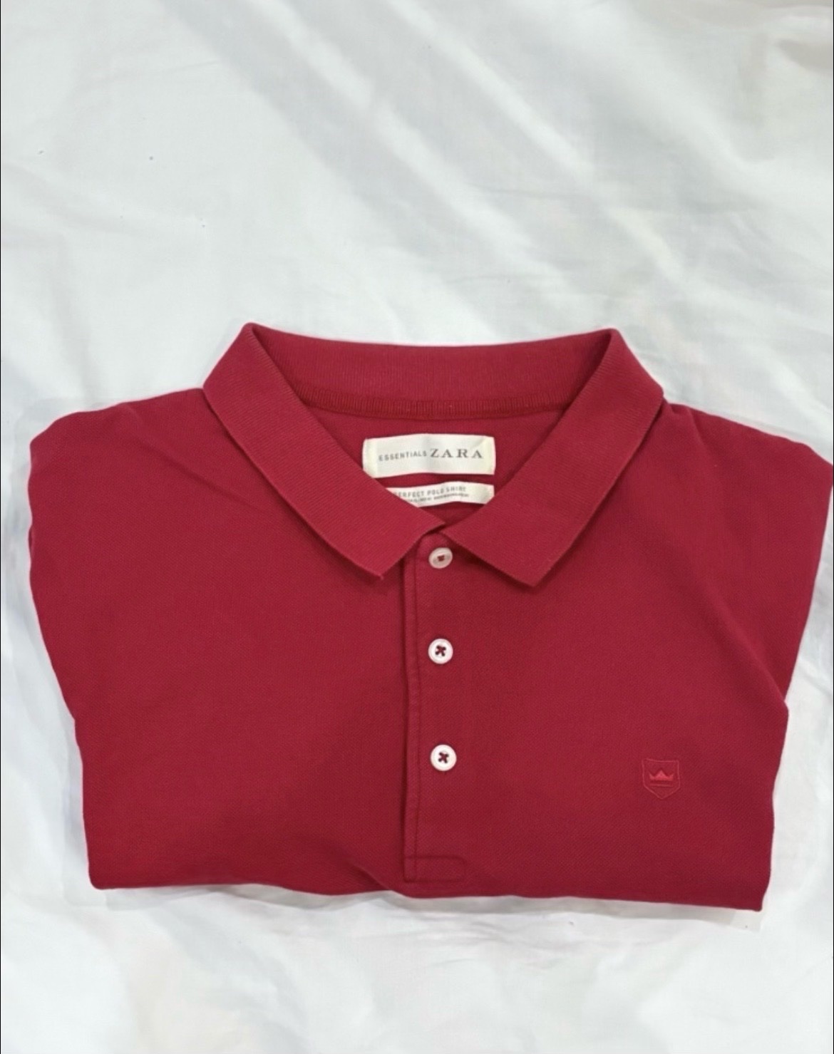 Polo rouge Zara avec un petit logo brodé en forme de couronne
