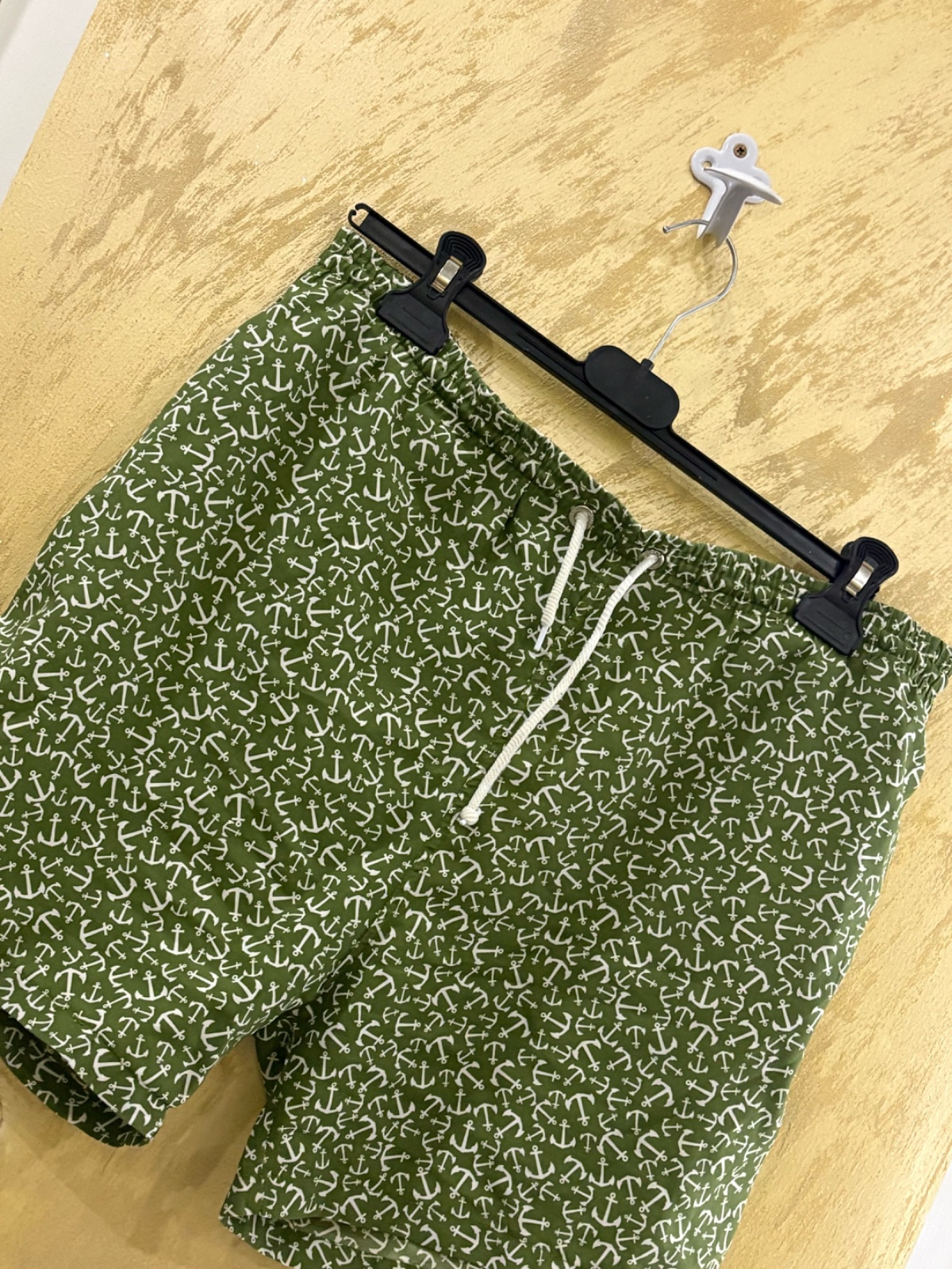 Maillot de bain pour homme de couleur kaki avec un motif d'ancres blanches, dotés d'une taille élastique avec un cordon de serrage blanc