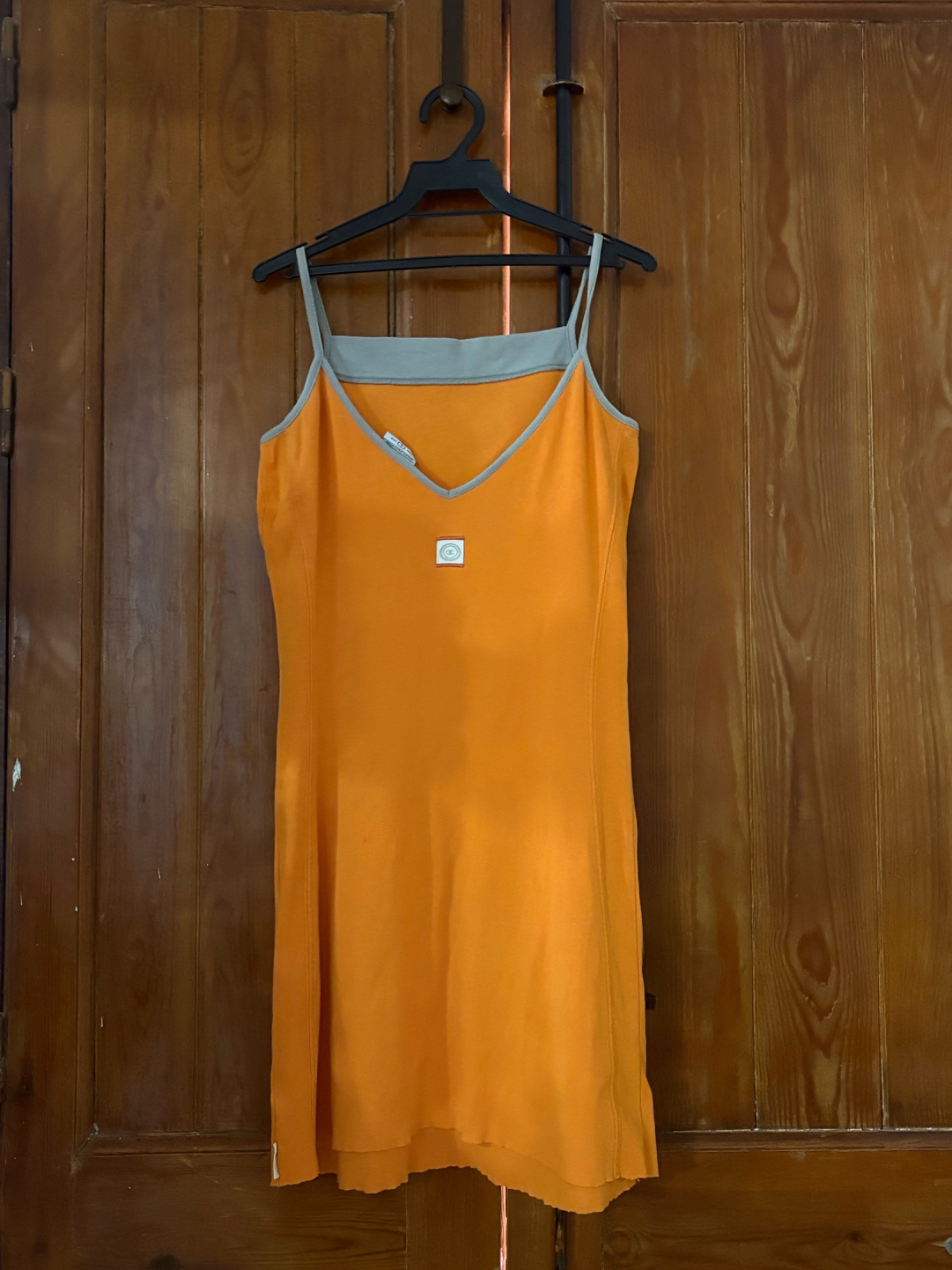 Robe orange de la marque Champion en coton éponge orange avec des bretelles fines est une pièce ajustée parfaite pour l'été