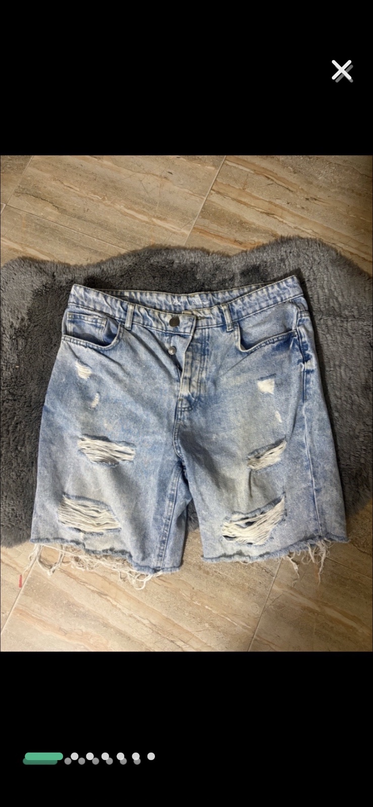 Short en jean bleu clair caractérisé par une coupe décontractée et des détails déchirés