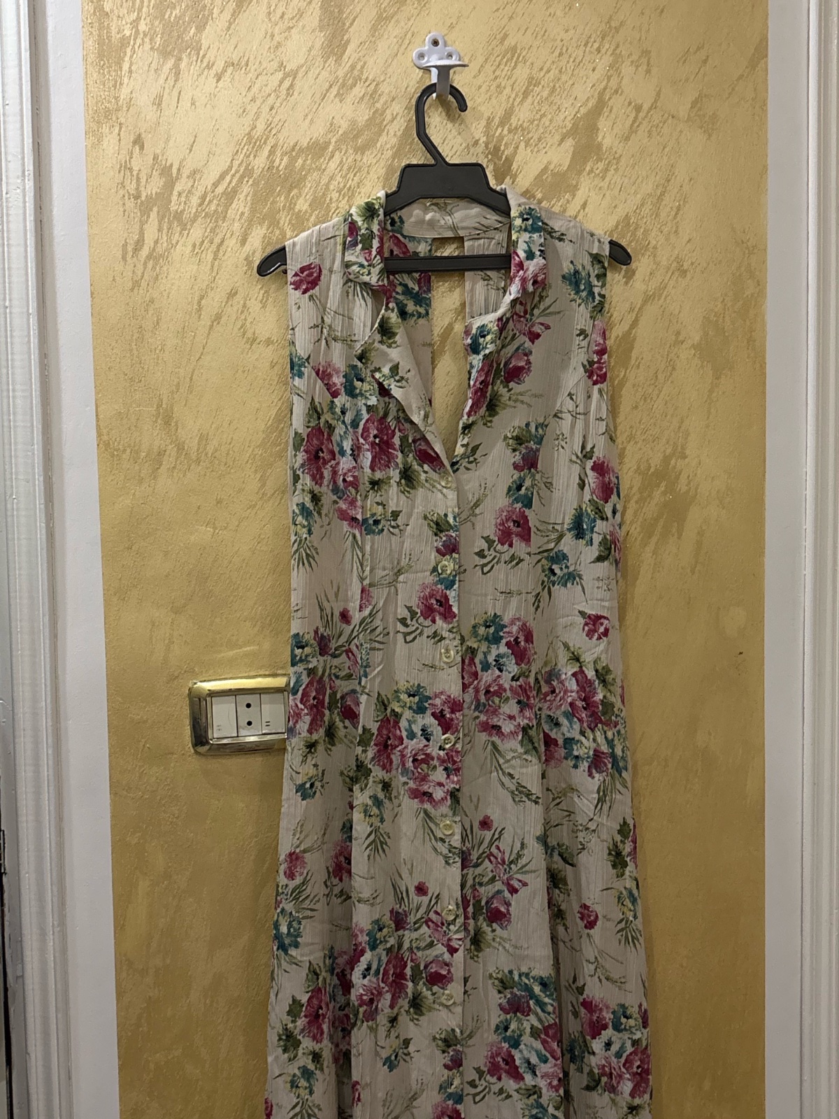 Robe sans manches de couleur beige arbore un motif floral composé de fleurs roses et bleues 