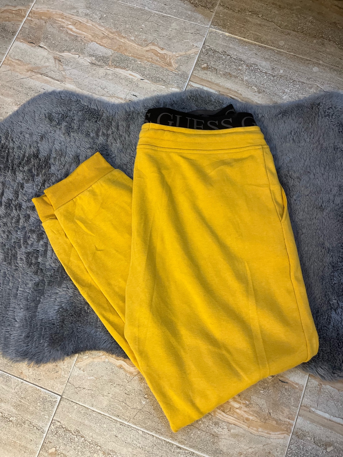  Pantalons GUESS en jaune moutarde avec une ceinture élastique noire arbore le logo de la marque en blanc et un cordon de serrage