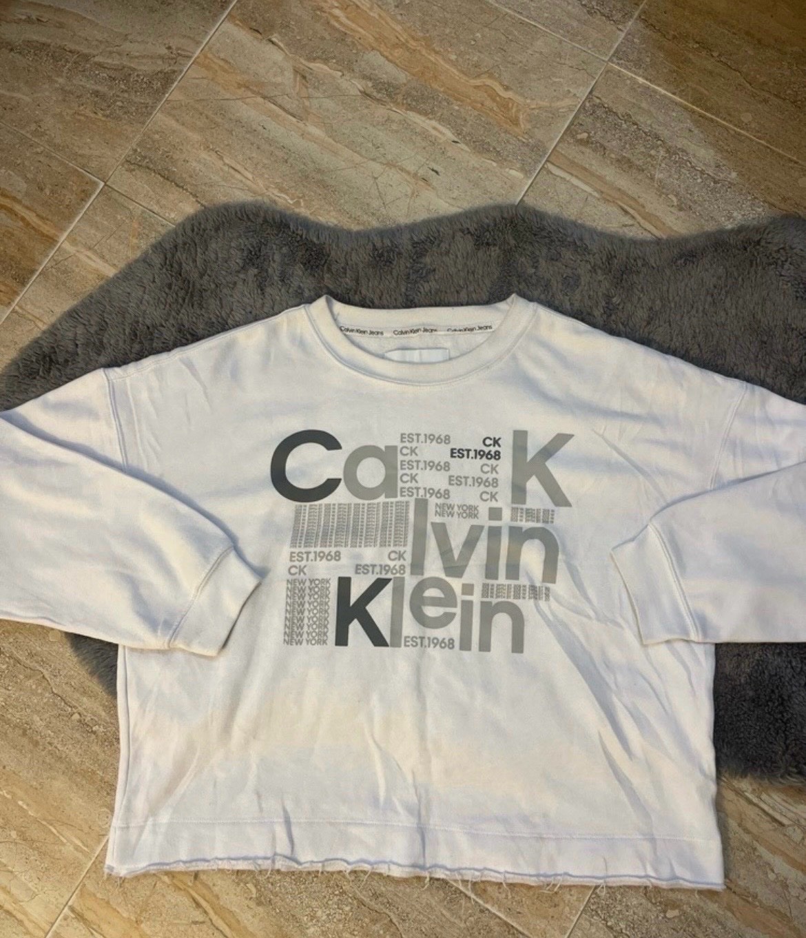 Pull molletonné blanc Calvin Klein à manches longues avec un motif graphique "CK Calvin Klein EST. 1968"