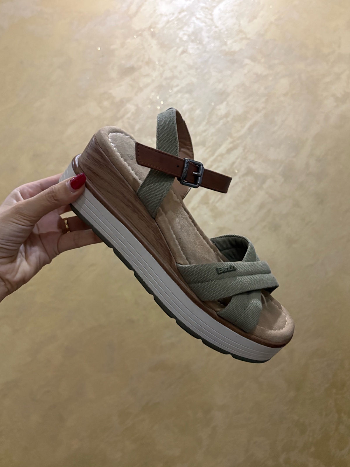 Sandales compensées de la marque Bench se distinguent par leurs larges brides croisées en toile vert olive associées à une lanière réglable en cuir marron et une semelle plateforme crantée
