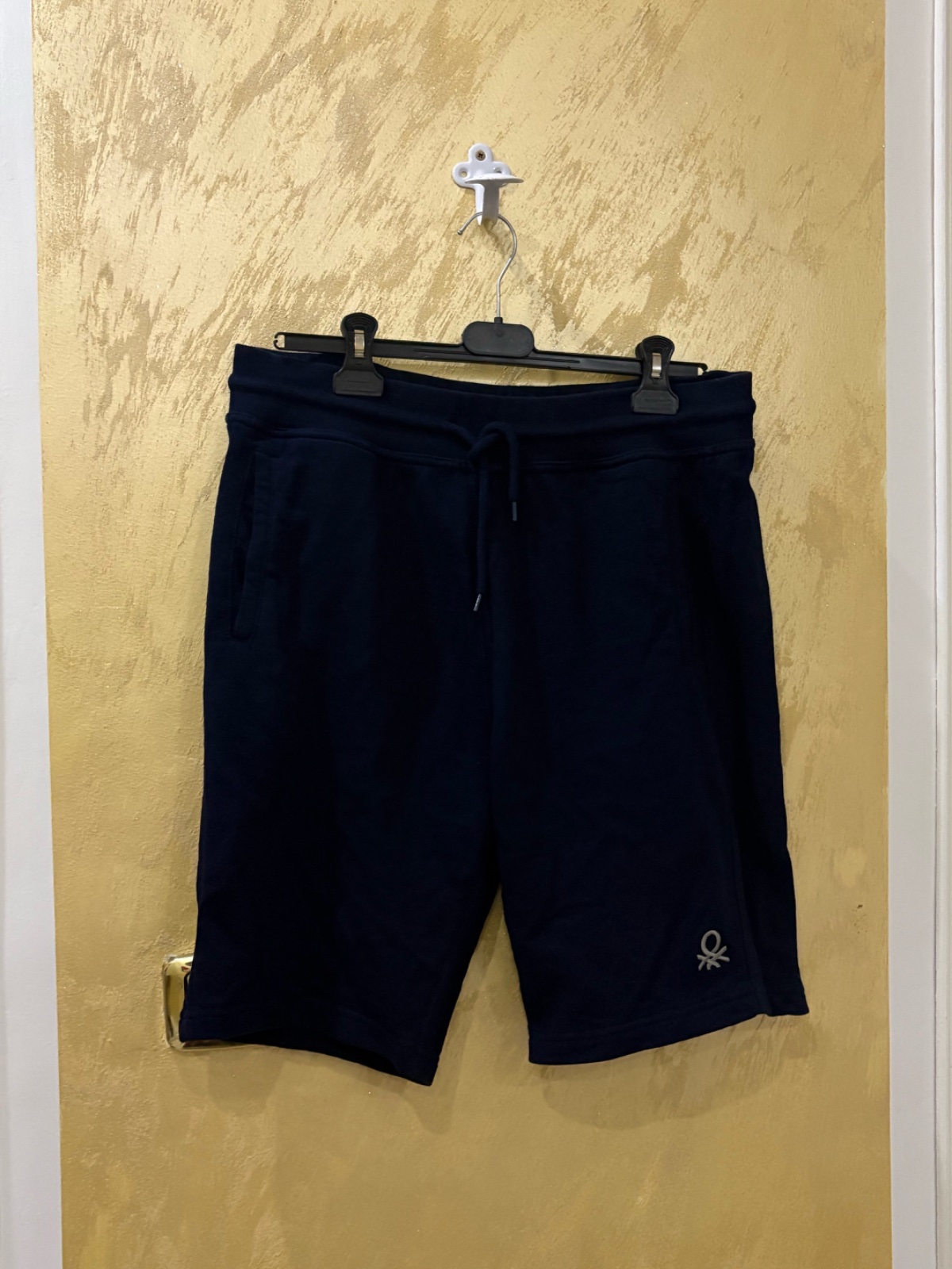 Short en molleton bleu foncé est un bermuda confortable de la marque United Colors of Benetton, reconnaissable à son petit logo brodé sur la jambe