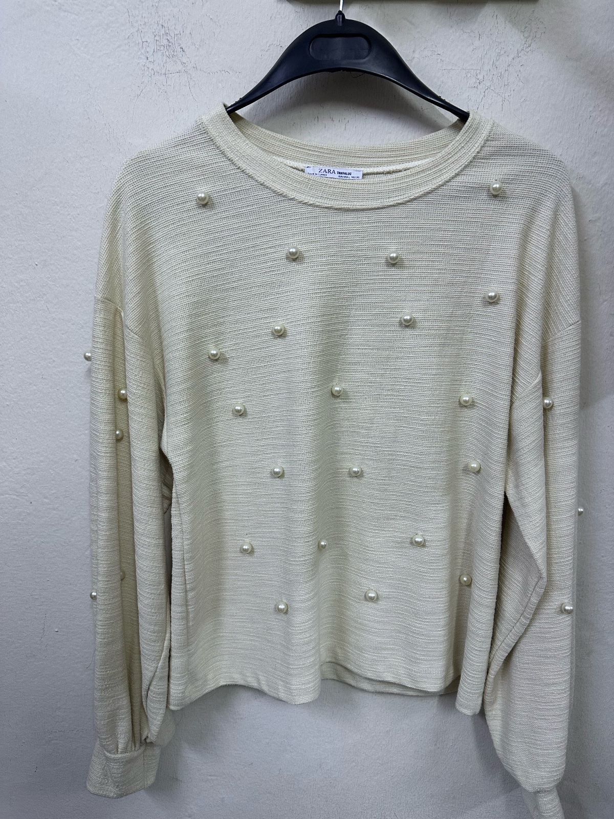 Pull Zara de couleur écru avec des perles artificielles. 