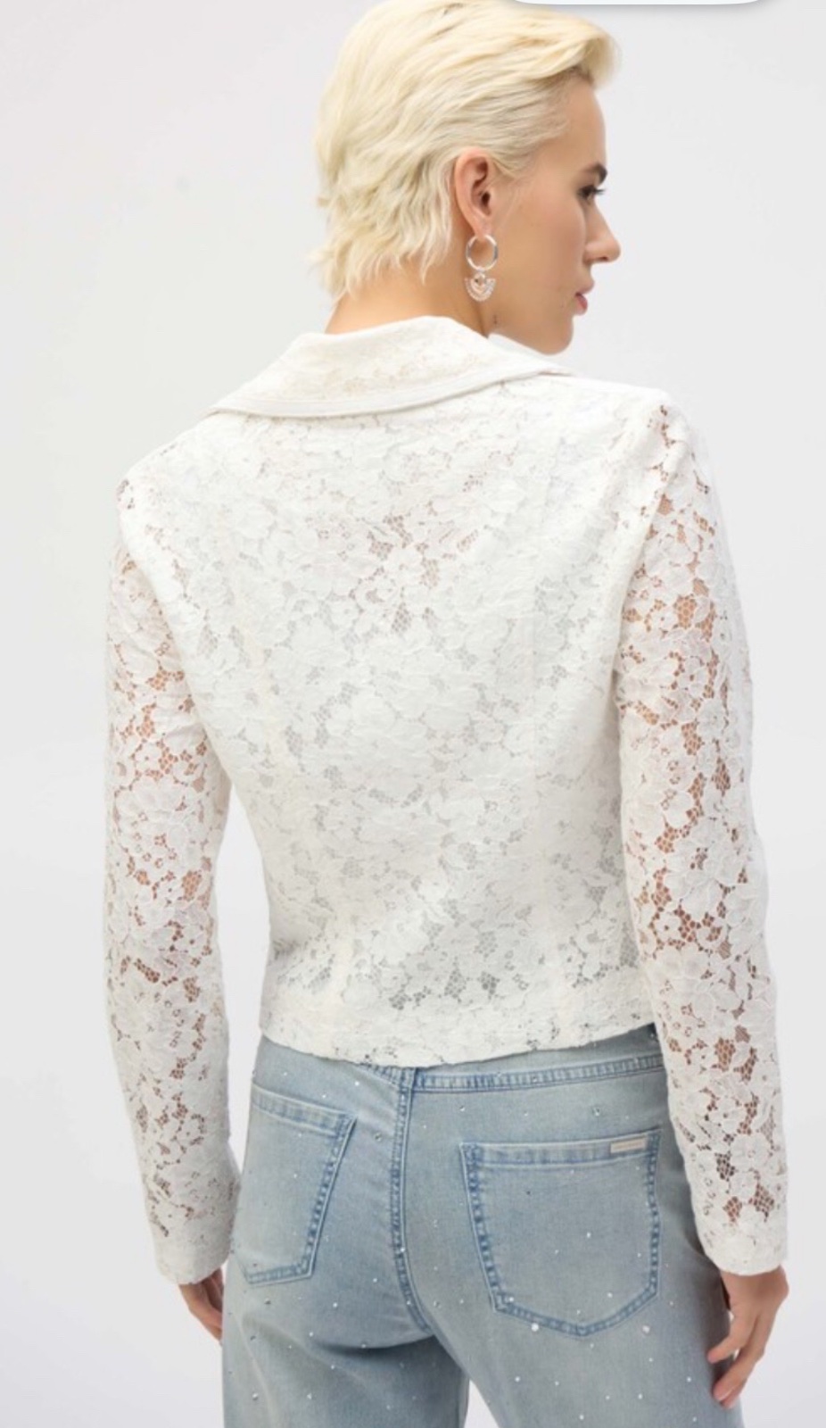 Une élégante veste courte en dentelle florale blanche dotée d'une fermeture zippée sur le devant