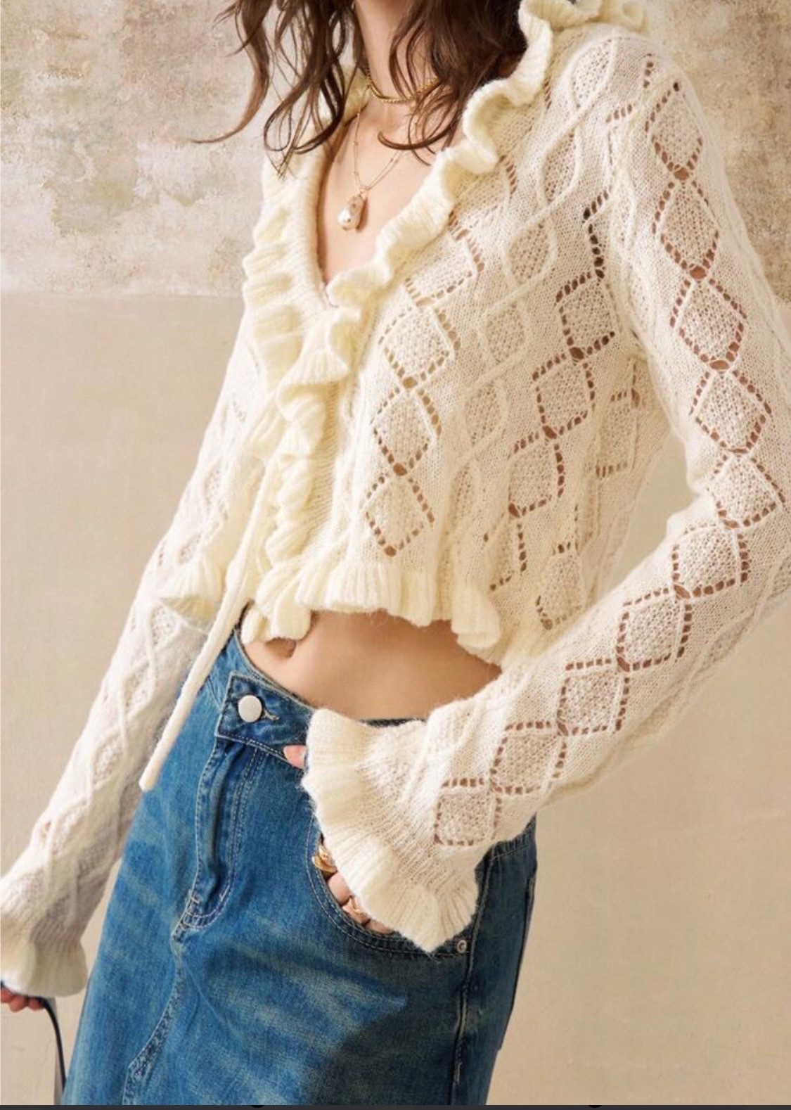 Cardigan écru en maille ajourée à motif losange, doté d'un col châle et de bordures volantées le long de l'ouverture et des poignets.