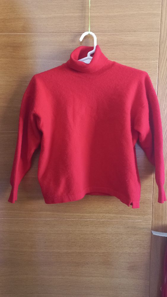 Un pull col roulé rouge de la marque André Maurice